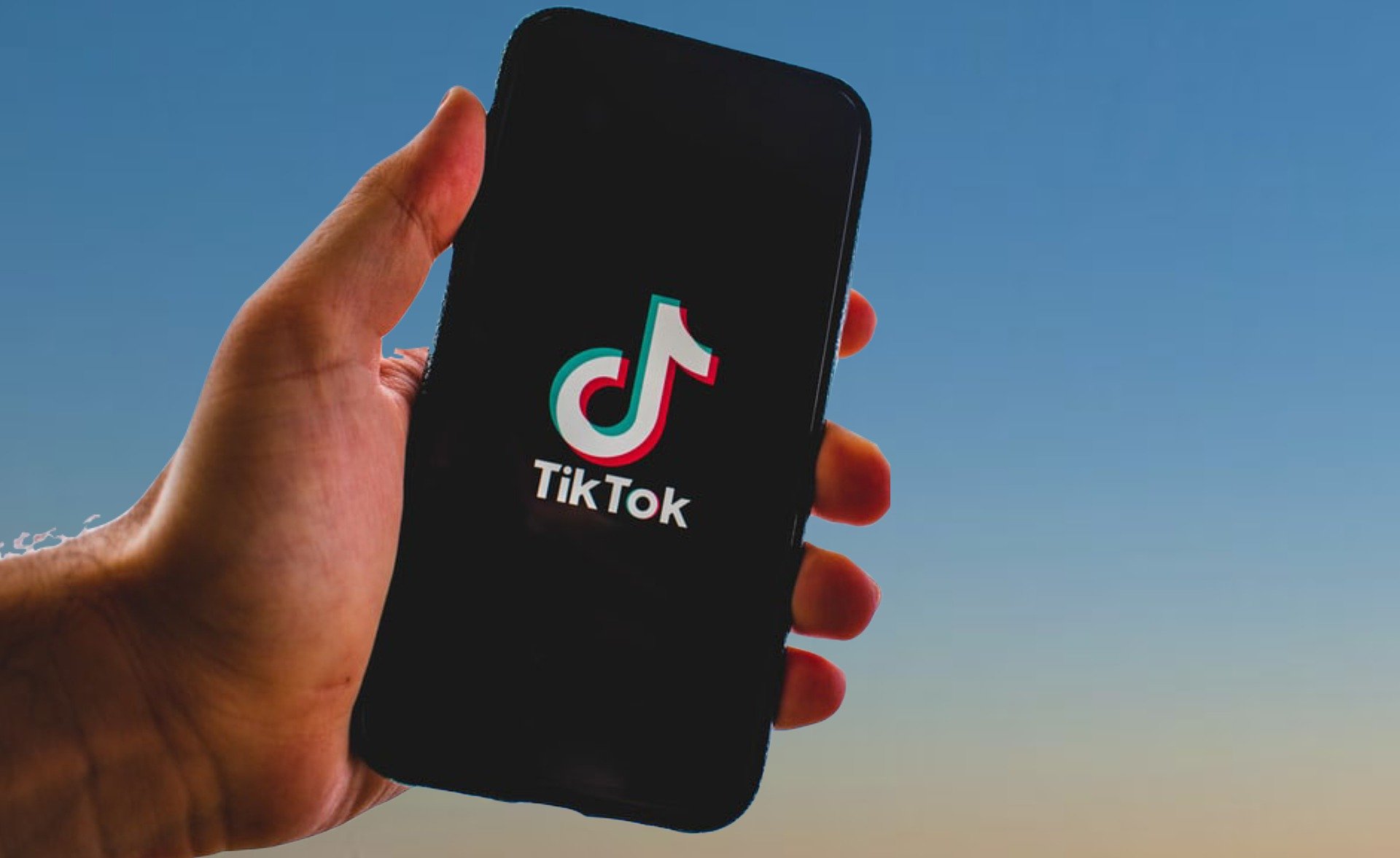 mão segundo celular com a logo do tiktok